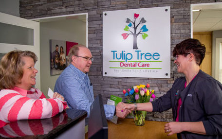 Patients who are going for restorative dentistry treatment are greeted at the reception desk at Tulip Tree Dental Care in South Bend, IN.